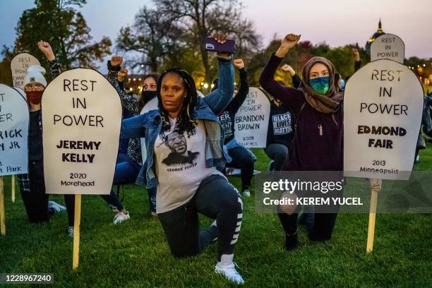 Protesters raise their fists and kneel during a demonstration after the release on bail of former police officer, Derek Chauvin, in Saint Paul,...