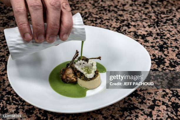 French chef Gilles Reinhardt prepares frog legs in the restaurant of Paul Bocuse "Auberge Du Pont de Collonges" in Collonges au Mont D'Or, near Lyon,...