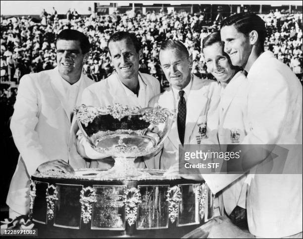 Australian players Bob Mark, Neale Fraser, Harry Hopman , Rod Laver and Roy Emerson pose with the David Cup trophy after winning the final against...