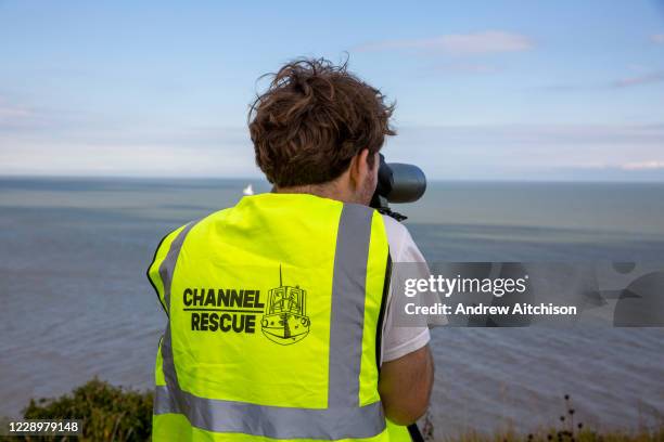 Group of Channel Rescue volunteers monitor the English Channel using telescopes and binoculars searching for small boats of people migrating across...