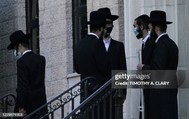 Members of the Orthodox Jewish community gather in the town of Monsey in New York's Rockland County, on October 9, 2020. - New restrictions are in...