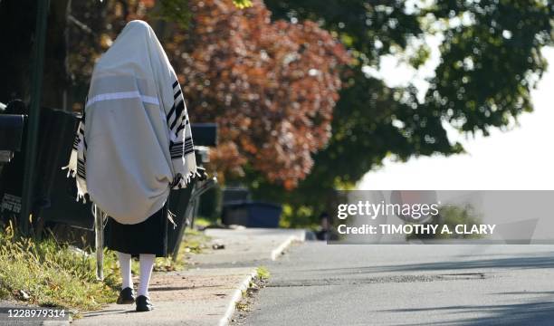 Member of the Orthodox Jewish community walks in the town of Monsey in New York's Rockland County, on October 9, 2020. - New restrictions are in...