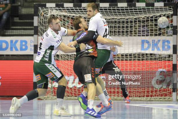 Christian O'Sullivan of SC Magdeburg is attacked by Jacob Bagersted and Kresimir Kozina during the LIQUI MOLY Handball-Bundesliga match between SC...