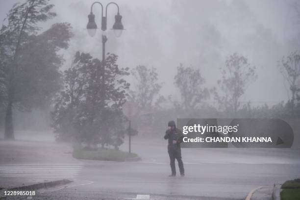 Reporter covers his face as he reports while Hurricane Delta makes landfall in Lake Charles, Louisiana on October 9, 2020. - Hurricane Delta made...