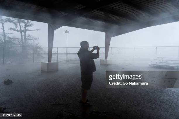 Person records rain and wind on his smartphone as Hurricane Delta makes landfall on October 9, 2020 in Lake Arthur, Louisiana. Hurricane Delta makes...