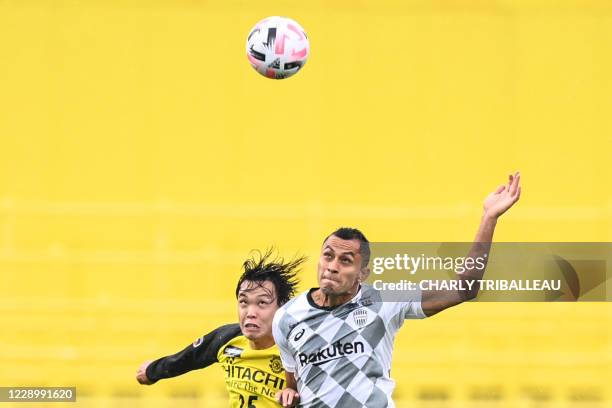 Kashiwa Reysol's Japanese defender Takuma Ominami vies for the ball with Vissel Kobe's Brazilian forward Douglas during the J-League football match...