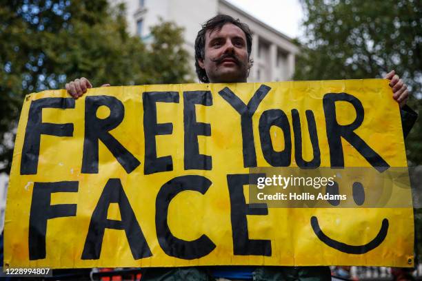 An anti-mask protestor holds a sign during a rally outside Downing Street on October 10, 2020 in London, England. Demonstrators rallied against the...