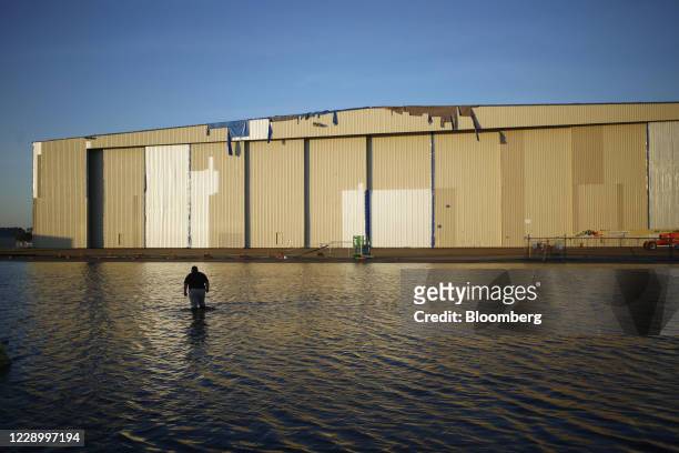Law enforcement officer walks through floodwater at Chennault International Airport after Hurricane Delta made landfall in Lake Charles, Louisiana,...