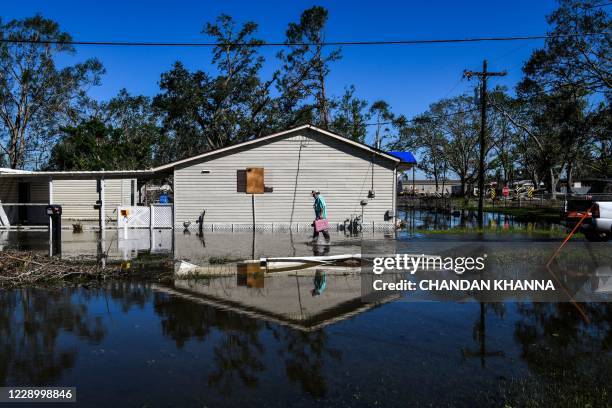 Daniel Schexnayder walks in flooded water outside his house after Hurricane Delta passed through the area on October 10, 2020 near Lake Charles,...