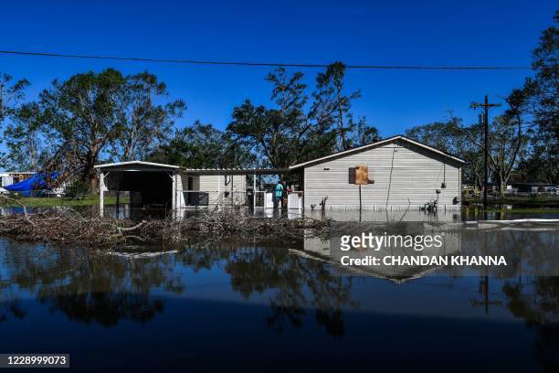 Daniel Schexnayder walks in flooded water outside his house, a day after Hurricane Delta passed through the area on October 10, 2020 near Lake...