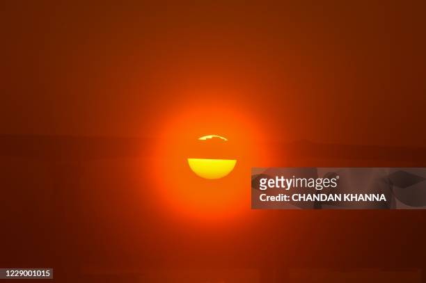 Sun sets behind a bridge a day after Hurricane Delta passed through the area in Lake Charles, Louisiana on October 10, 2020. - Hurricane Delta made...