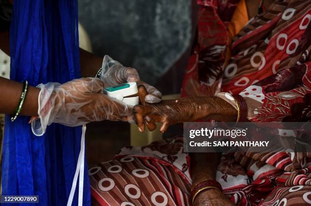 Covid-19 Awareness Project' volunteer uses an oximeter to check on a patient infected with leprosy as part of a general health checkup for all...