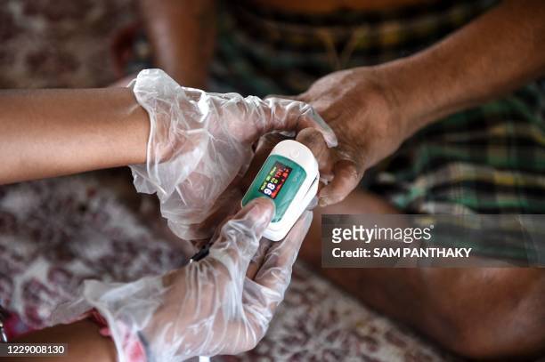 Covid-19 Awareness Project' volunteer uses an oximeter to check on a patient infected with leprosy as part of a general health checkup for all...