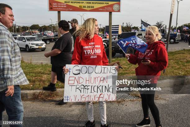 Woman holds a sign for the QAnon conspiracy theory during a pro-Trump rally on October 11, 2020 in Ronkonkoma, New York. With President Trump testing...