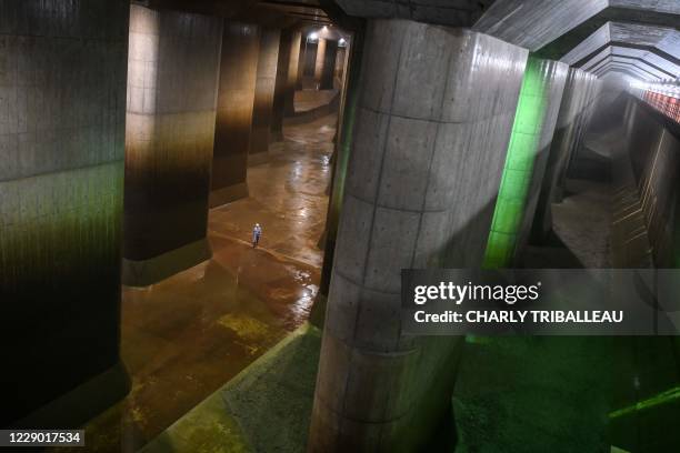 In this photo taken on September 3 an employee walks in the water tank of the metropolitan outer underground discharge channel in Kasukabe, Saitama...