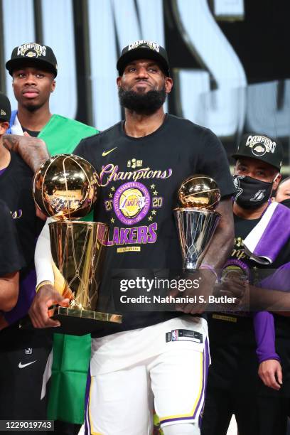 LeBron James of the Los Angeles Lakers holds the Larry O'Brien Trophy and The Bill Russell NBA Finals MVP Award after winning Game Six of the NBA...