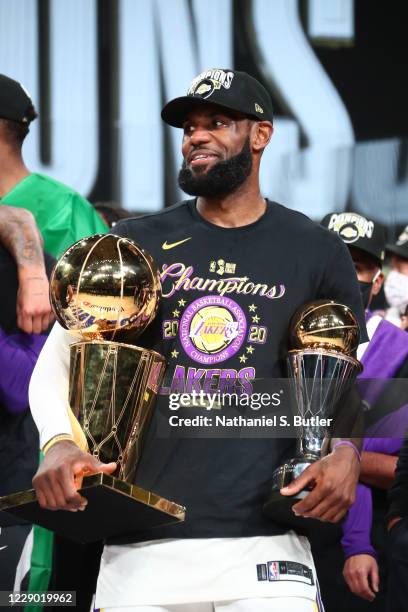 LeBron James of the Los Angeles Lakers holds the Larry O'Brien Trophy and The Bill Russell NBA Finals MVP Award after winning Game Six of the NBA...