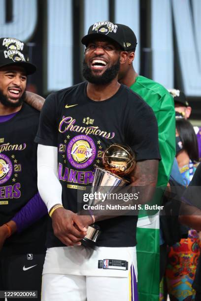 LeBron James of the Los Angeles Lakers holds the Larry O'Brien Trophy and The Bill Russell NBA Finals MVP Award after winning Game Six of the NBA...