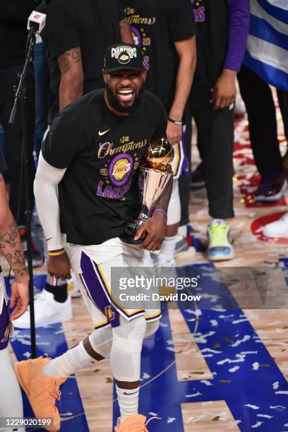 LeBron James of the Los Angeles Lakers celebrates after receiving the Bill Russell Finals MVP Trophy after Game Six of the NBA Finals on October 11,...