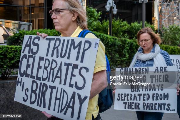 Activist holding placards during the demonstration on Trumps birthday outside the Trump International Hotel to peacefully draw attention to the...