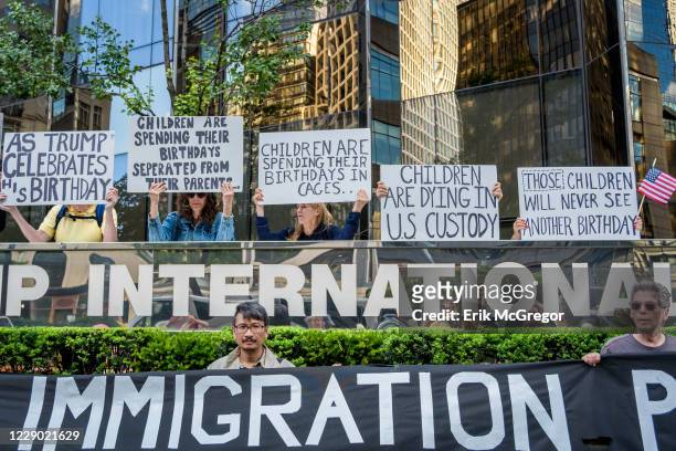 Activist holding placards and banner during the demonstration on Trumps birthday outside the Trump International Hotel to peacefully draw attention...