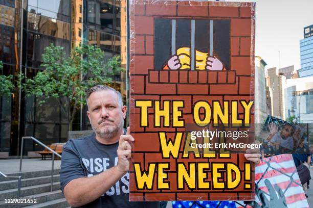 An activist holding a placard during the demonstration on Trumps birthday outside the Trump International Hotel to peacefully draw attention to the...