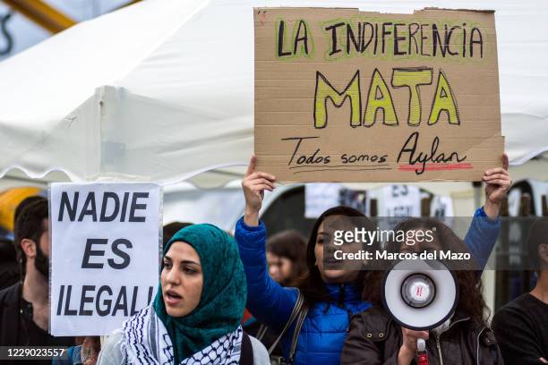 People protesting against EU-Turkey agreement with refugees during a 24 hour vigil. A woman holds a placard that reads "Indifference kills. We are...