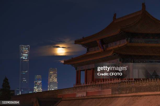 Bright moon rises, the ancient palace museum and the modern CBD building complement each other. Beijing, China, September 3, 2020. -