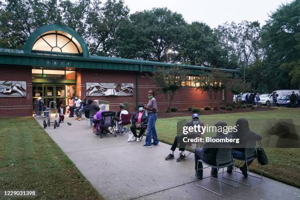 Residents wait in line outside an early voting polling location for the 2020 Presidential election in Atlanta, Georgia, U.S., on Monday, Oct. 12,...