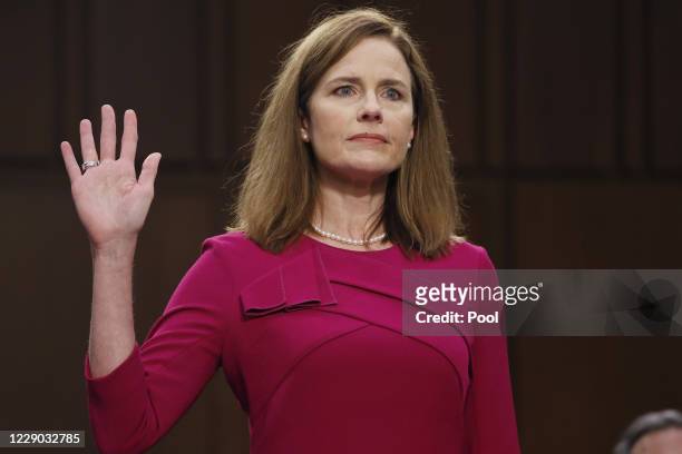 Supreme Court Justice nominee Judge Amy Coney Barrett stands as she is sworn in during the Senate Judiciary Committee confirmation hearing for...