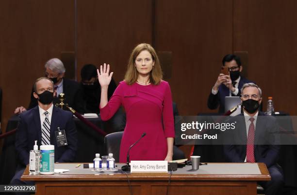 Supreme Court Justice nominee Judge Amy Coney Barrett stands as she is sworn in during the Senate Judiciary Committee confirmation hearing for...