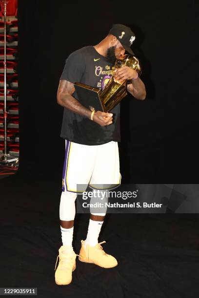 LeBron James of the poses with the Larry O'Brien Trophy after winning Game Six of the NBA Finals on October 11, 2020 at AdventHealth Arena in...