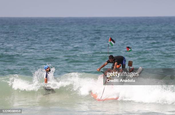 Palestinian youth Muhammad Al-Radi test rides his pedal boat, which he made from scrap iron and plastic during the lockdown imposed as a measure...