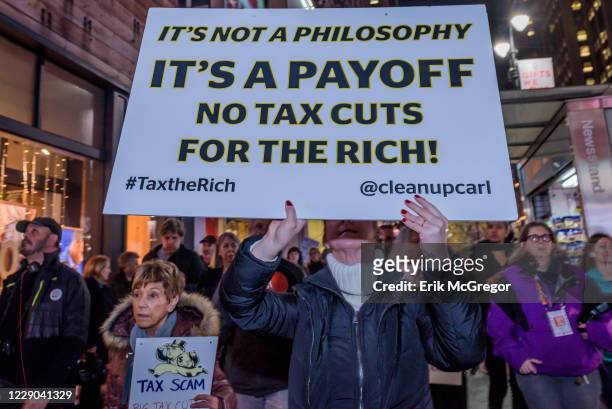 Over a hundred protesters met at Greeley Square in Midtown Manhattan on November 27, 2017 and marched along 34th Street behind a Not One Penny of Tax...