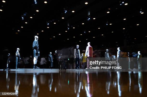 This long exposure picture shows people visiting an installation presenting creations from fashion brand TAAKK by designer Takuya Morikawa for the...