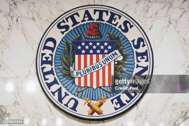 The U.S. Senate seal hangs on the hearing room wall on the second day of the Supreme Court confirmation hearing for Judge Amy Coney Barrett before...