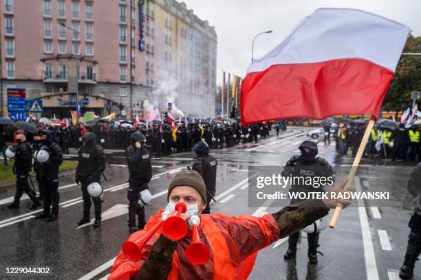 Man weaves a Polish flag on the street during a protest of Polish farmers against an animal rights bill that would ban the breeding of animals for...