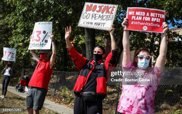 Liv Chaffee, center, a teacher at Blackstone School, waves at passerby during a protest in Boston's Dorchester on Oct. 10, 2020. Teachers, parents,...