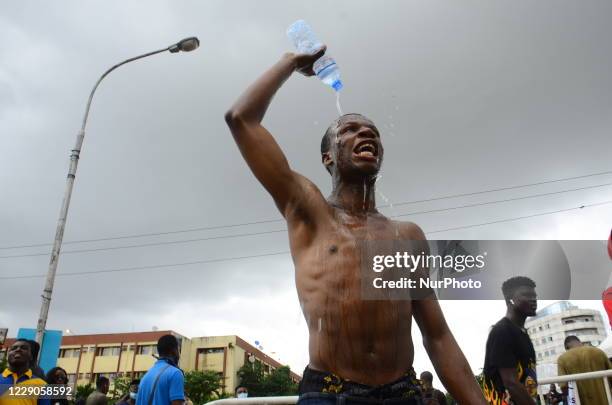 Youth of ENDSARS protesters pure water on his head during the ongoing protest against the harassment, killings and brutality of The Nigerian Police...