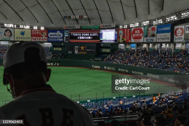 Fans sit in socially distanced seats as they wait to watch the Japan Central League baseball match between Yomiuri Giants and Hiroshima Carp at Tokyo...