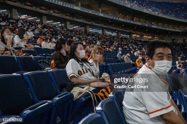 Fans sit in socially distanced seats as they wait to watch the Japan Central League baseball match between Yomiuri Giants and Hiroshima Carp at Tokyo...