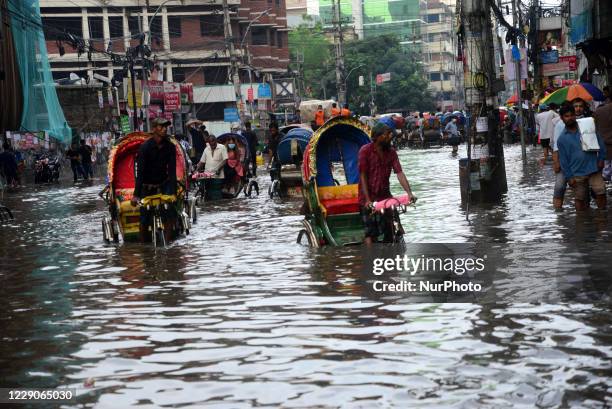 Vehicles try driving and citizens are walking through the water logging Dhaka streets in Bangladesh, on October 14, 2020. Heavy monsoon downpour...