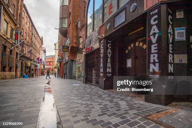 Pedestrians walk past closed bars on Mathew Street, home to the The Cavern Club, as the region heads into a level 3 local lockdown, in Liverpool,...