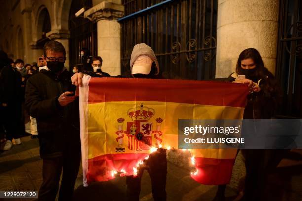 Supporters of Catalonia's Committees for the Defence of the Republic burn a Spanish flag during a pro-independence protest in Barcelona on October...