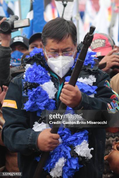 Presidential candidate of MAS Luis Arce holds an indigenous baton as making an offering to Mother Earth during a MAS closing rally ahead of...