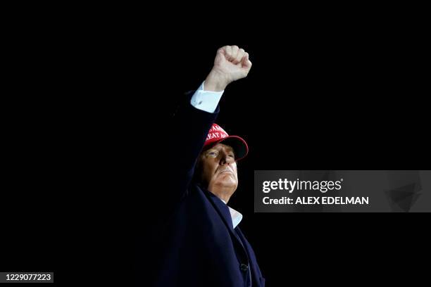 President Donald Trump pumps his fist as he hosts a Make America Great Again campaign event at Des Moines International Airport in Des Moines, Iowa...