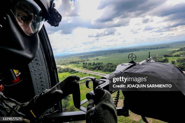 Colombian Air Force soldier is pictured as he holds an alert position onboard a blackhawk helicopter overflying the Gulf of Uraba during a...