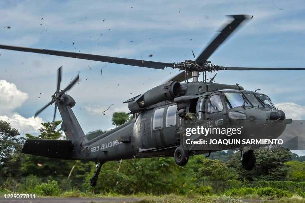 Colombian Air Force soldier is pictured as he holds an alert position on a blackhawk helicopter during a surveillance mission in which also school...