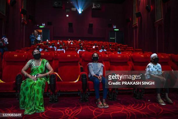 People invited as 'Covid-19 warriors' and their families to a special screening watch Bollywood movie 'Tanhaji' in a cinema in New Delhi on October...