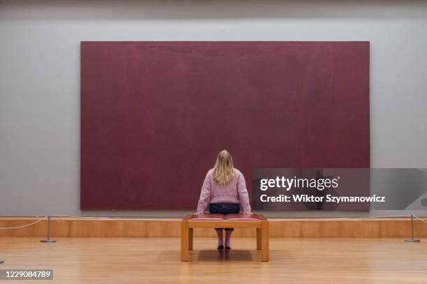 Gallery staff member looks at Mark Rothko's The Seagram Murals: Red on Maroon oil paint, pigment and glue on canvas during a photocall to promote...